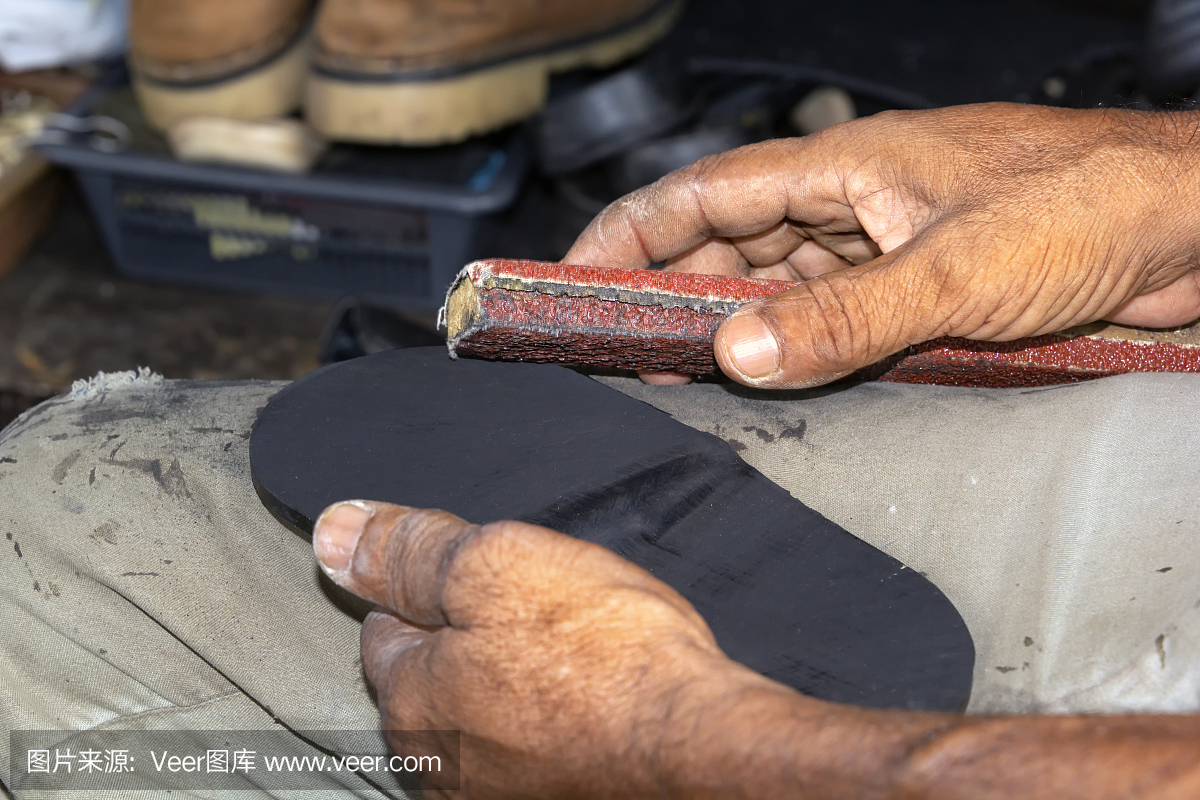 街头作坊里,鞋匠在打磨旧运动鞋的鞋底。